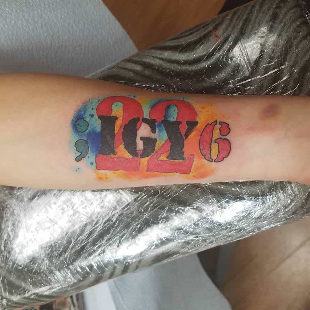 Forearm tattoo with "22 ;IGY6" in bold colors, including red, blue, orange, and yellow