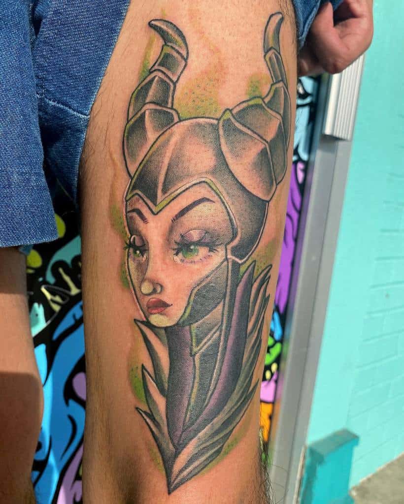 Striking Maleficent thigh tattoo with a modern twist, featuring bold lines, soft shading, and vibrant green accents for a magical touch