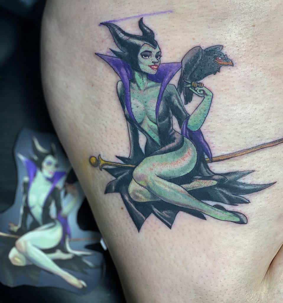 Tattoo of Maleficent in green and black attire with a staff and raven on an arm