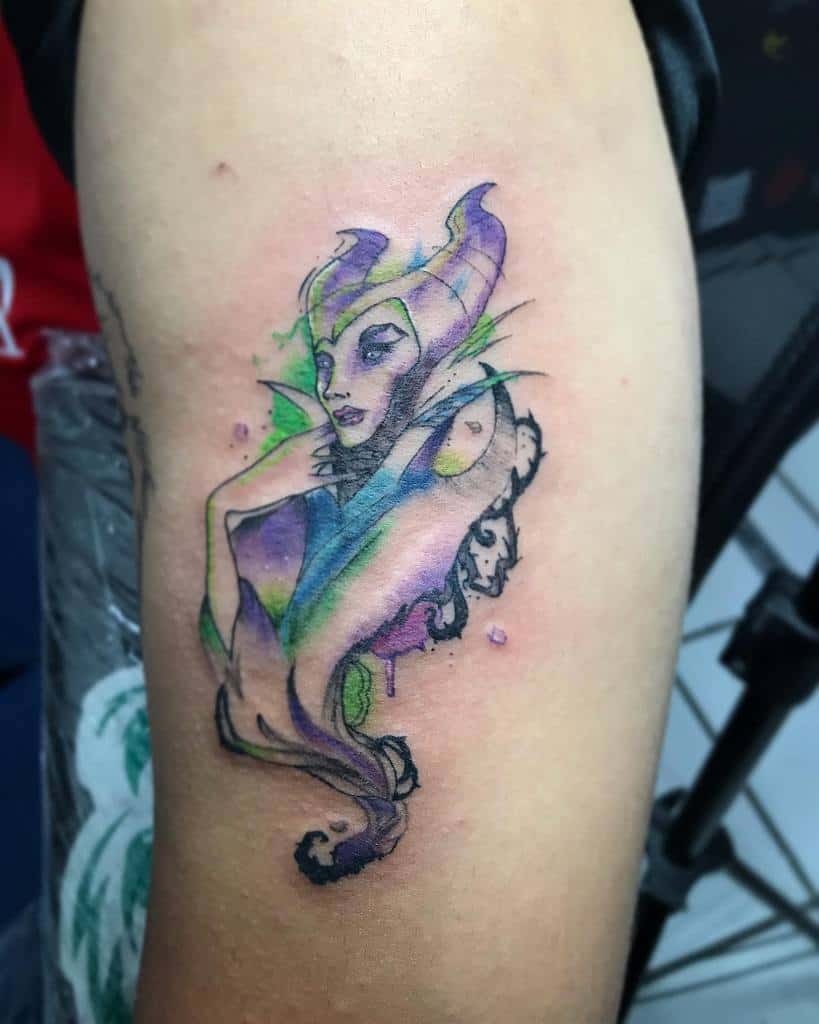 Delicate watercolor Maleficent tattoo with ethereal blue, green, and purple hues, creating a mystical and artistic design