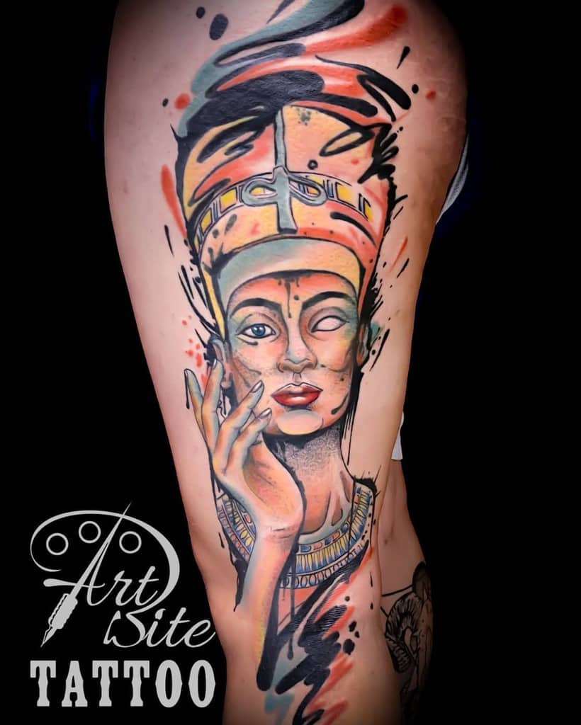 Colorful tattoo of an Egyptian queen with abstract accents on a thigh