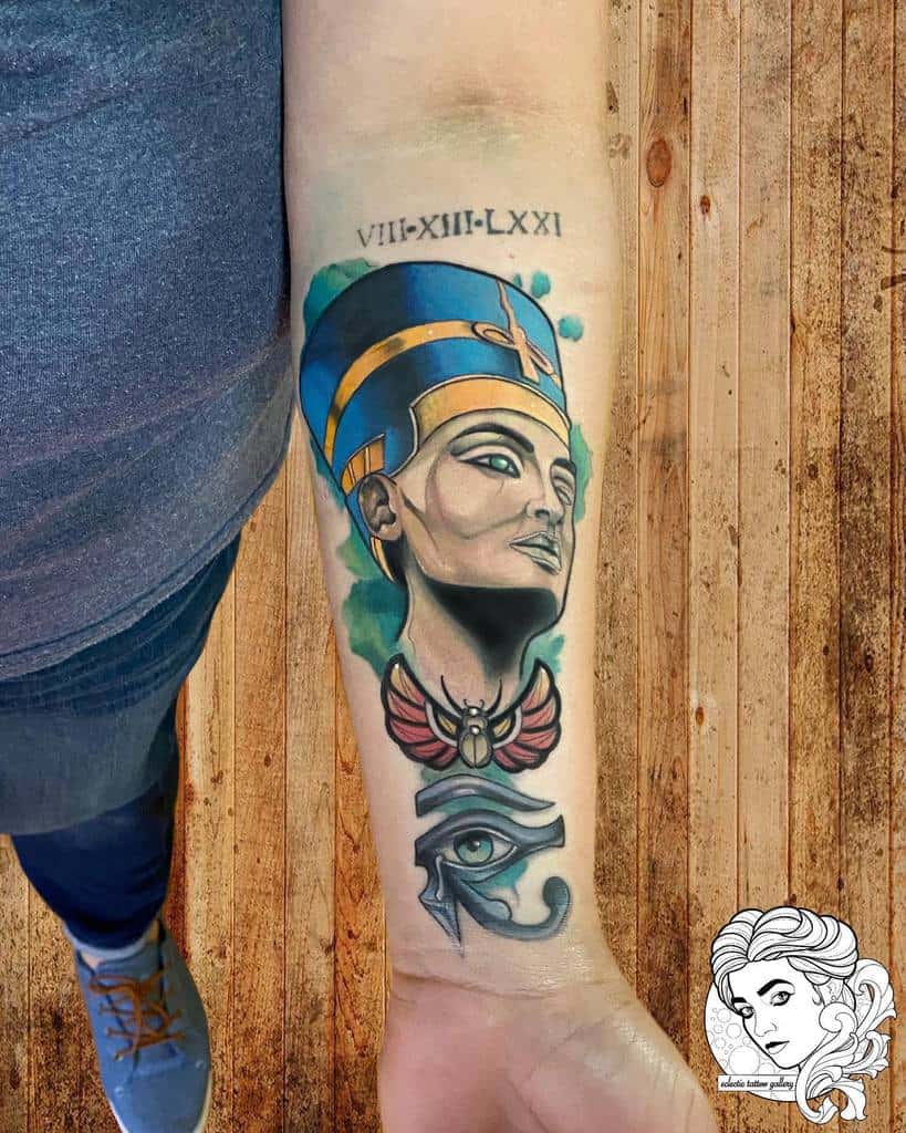 Forearm tattoo of an ancient Egyptian figure, an Eye of Horus, and Roman numerals