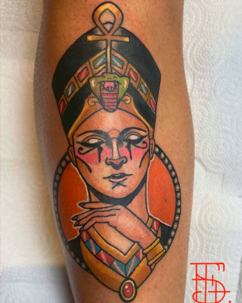 Colorful tattoo of an ancient Egyptian figure with a headdress and ankh on an arm