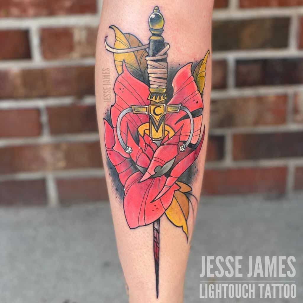 Tattoo of a dagger through a red rose with abstract elements on a leg