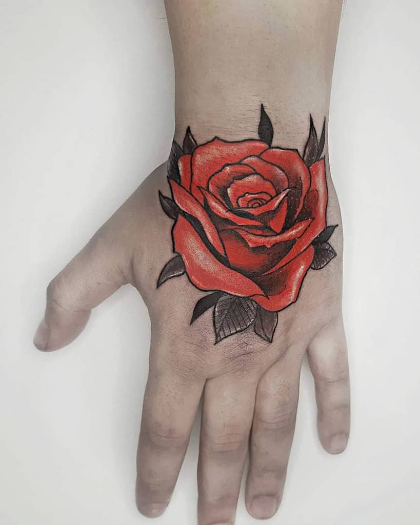 A vibrant red rose tattoo on the back of a hand