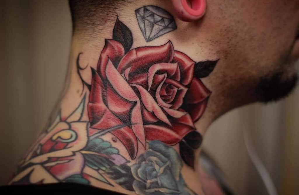 Close-up of a neck tattoo featuring a red rose and a diamond