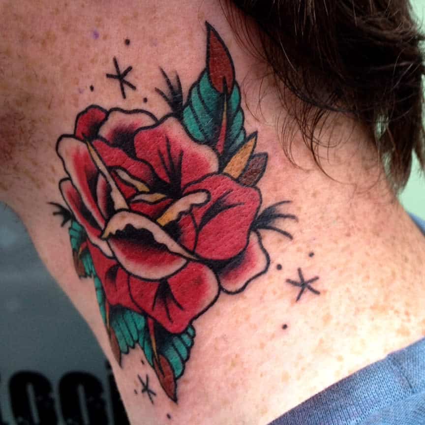 A stunning neck tattoo featuring a vibrant red rose intertwined with lush green leaves and delicate star accents