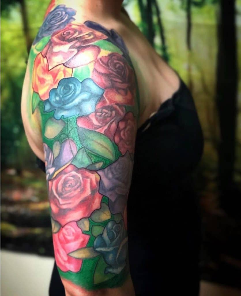 Colorful rose tattoo sleeve on a woman's arm