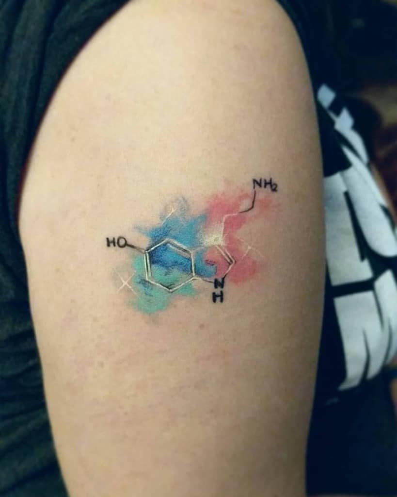 Watercolor serotonin tattoo on arm with pastel colors
