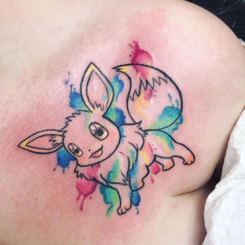 Playful Eevee tattoo with a vibrant watercolor splash background in rainbow hues, adding a whimsical and dynamic feel