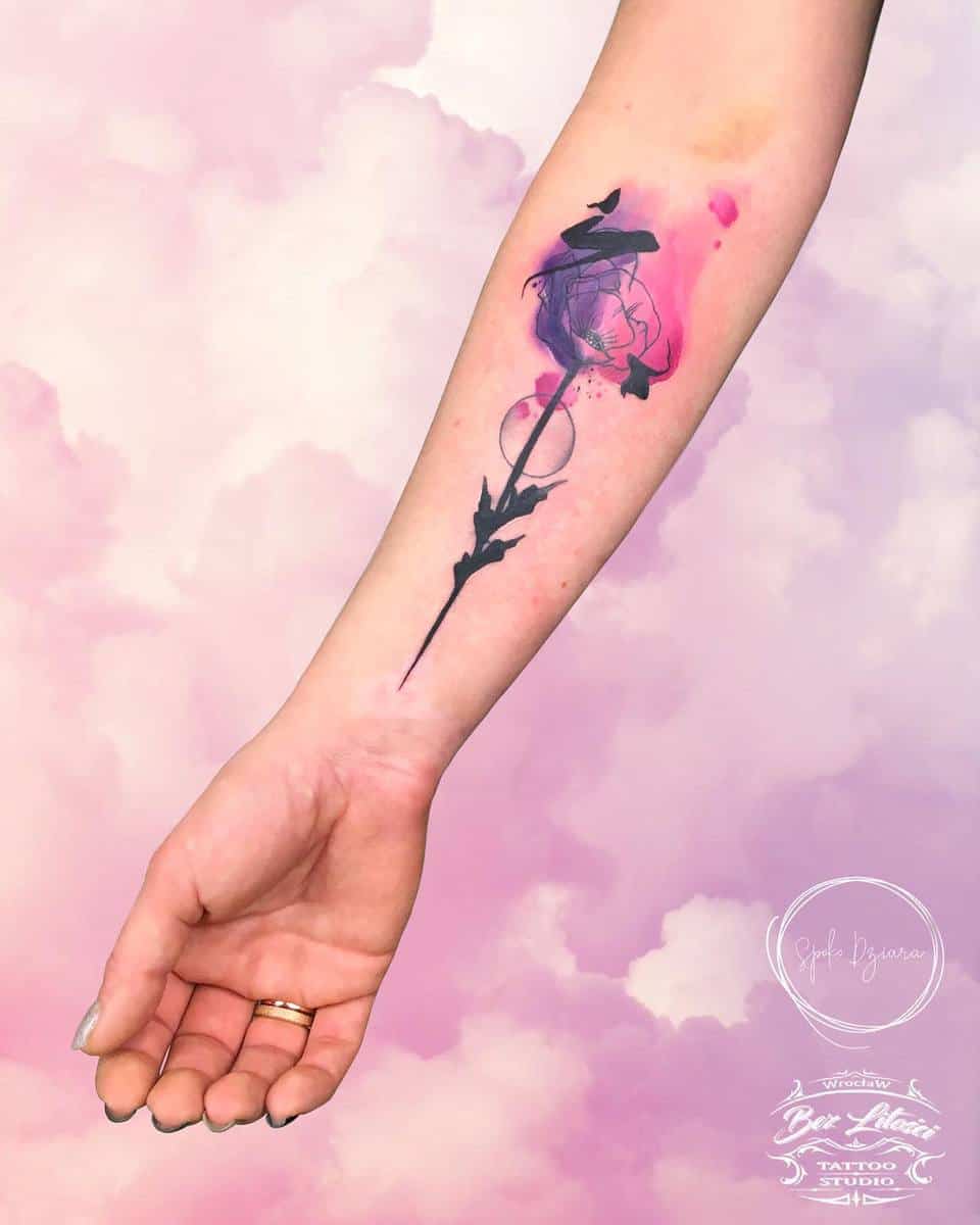 Forearm tattoo of a purple and pink abstract flower