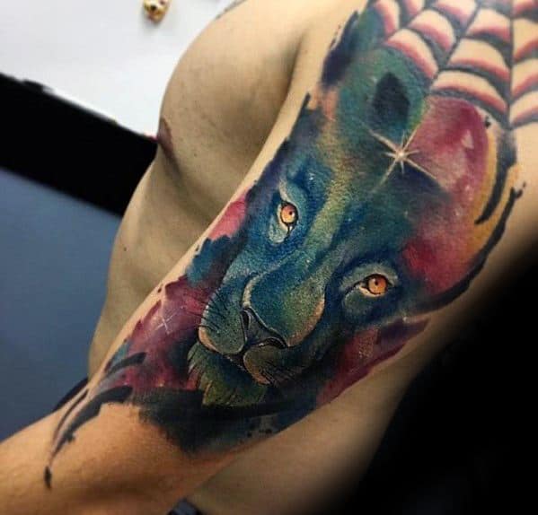 Colorful lion tattoo resembling a nebula on a person's upper arm, with vibrant hues and intricate details