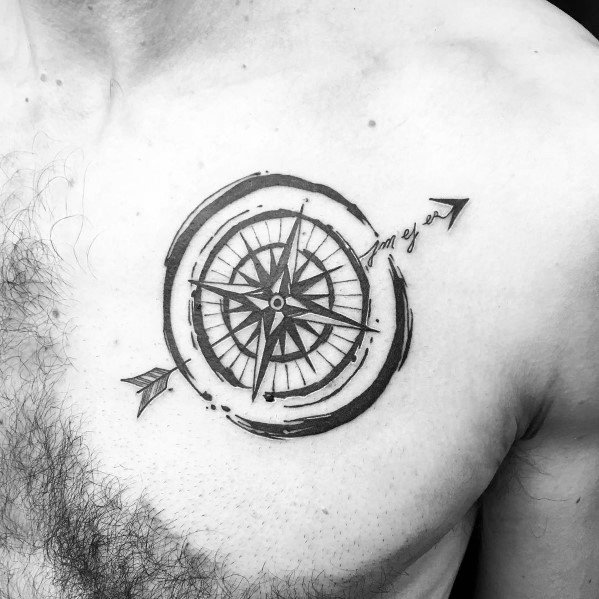Compass tattoo with an arrow and brushstroke design on the chest, symbolizing direction, movement, and personal journey.