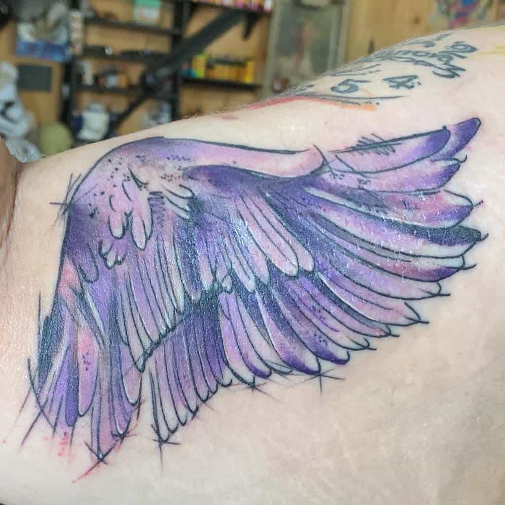 Beautiful purple angel wing tattoo with a soft watercolor effect, symbolizing spirituality, freedom, and protection