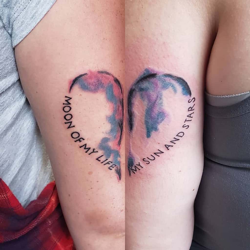 Matching sister tattoos featuring a cosmic watercolor design forming a heart when placed together, with the phrases 'Moon of My Life' and 'My Sun and Stars' inspired by Game of Thrones