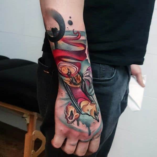 A vibrant, cosmic-themed abstract tattoo spans the forearm and hand, reminiscent of a pencil sketch brought to life with a burst of color