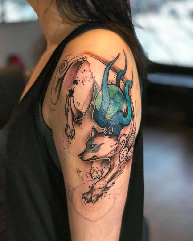 Stunning watercolor Okami tattoo featuring a dynamic wolf with ethereal blue flames, flowing ink splashes, and bold black outlines