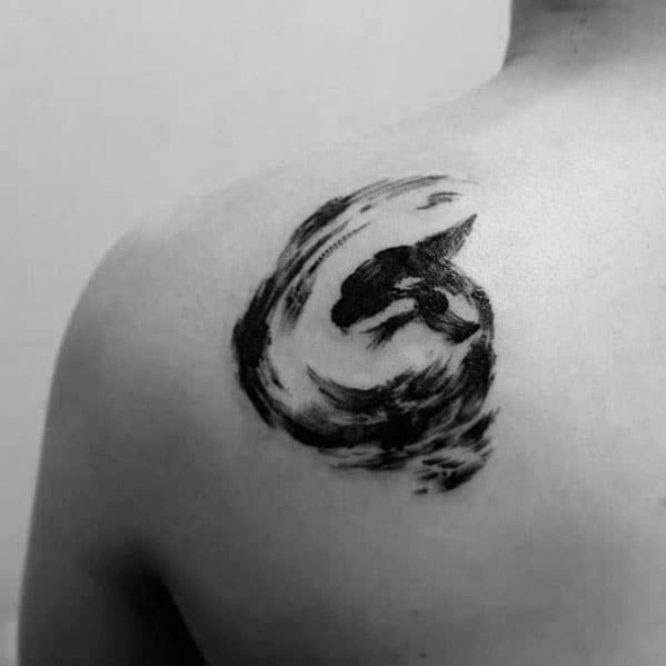 Dynamic black ink orca tattoo on the shoulder, featuring a swirling motion that captures the whale's movement in an abstract, artistic style.