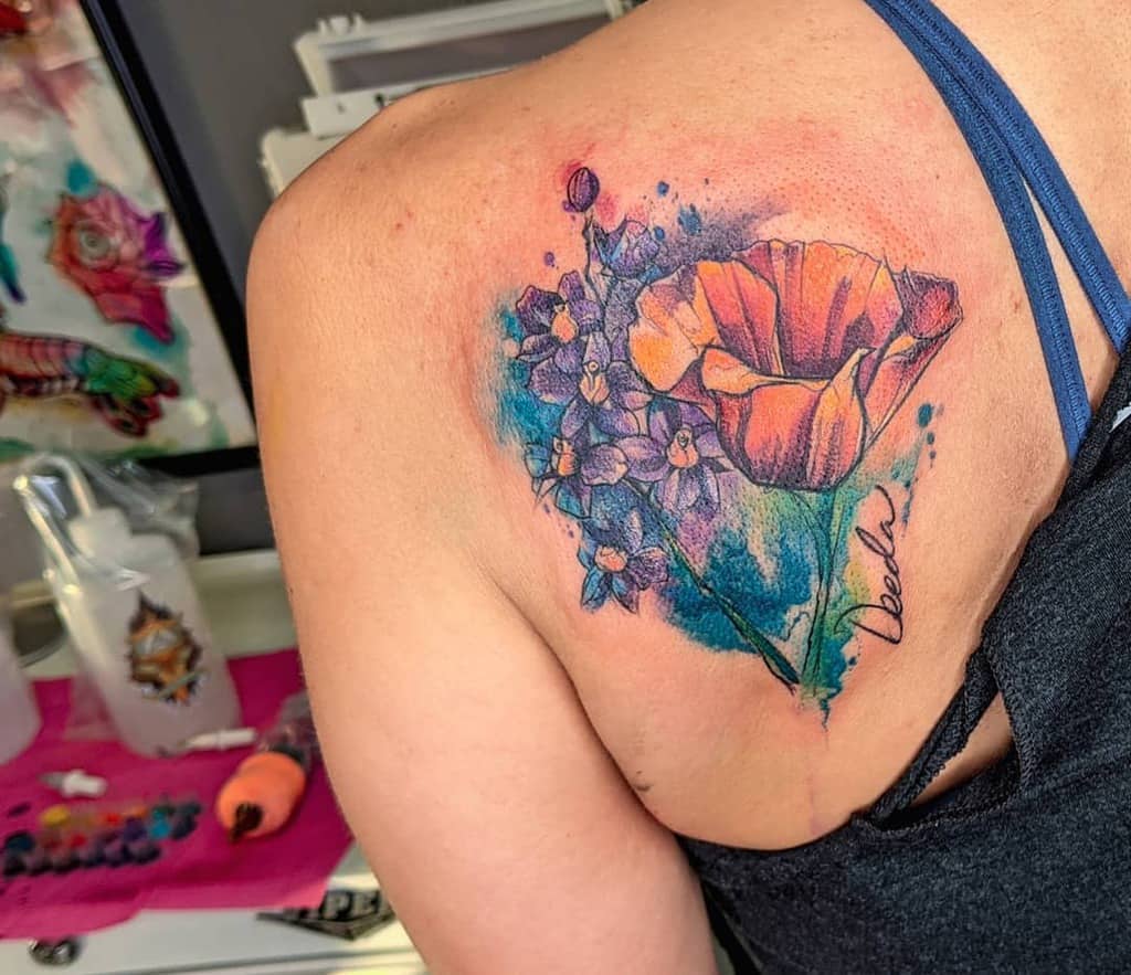 Colorful floral tattoo on a person's shoulder with a poppy and other flowers