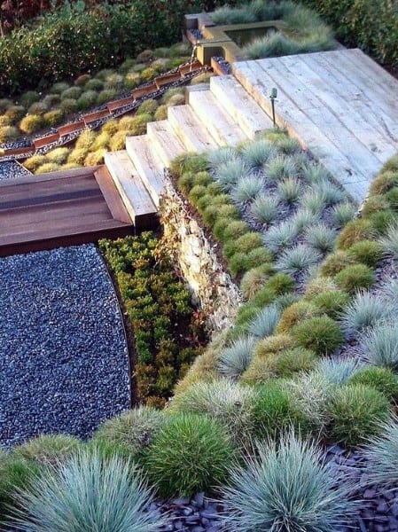 Terraced garden with stone steps, lush greenery, and a cascading waterfall feature.