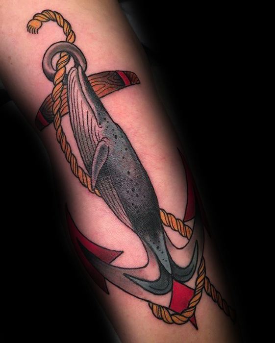 Tattoo of a majestic whale entwined with an anchor on a forearm