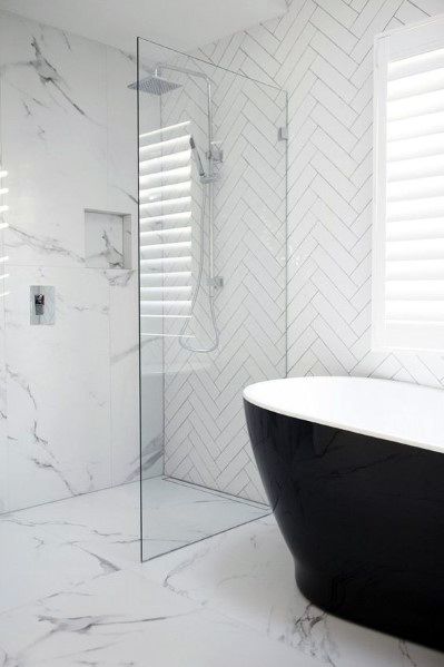 Modern bathroom with a white marble shower and a black freestanding bathtub