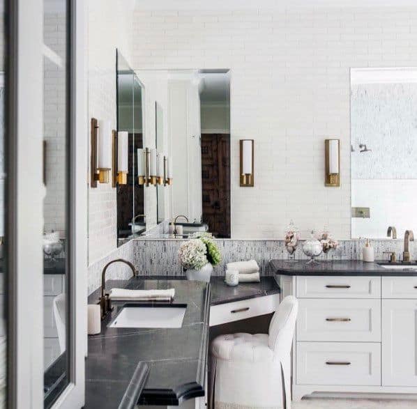 White bathroom vanity with black marble countertop and built-in makeup station.