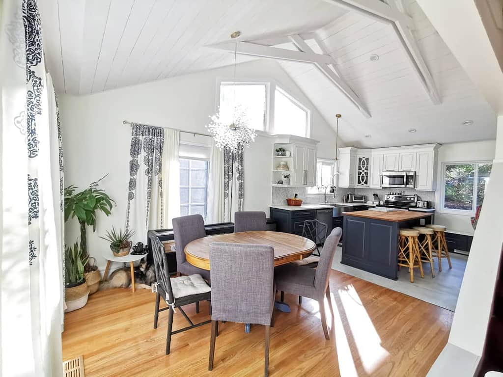 vaulted ceiling kitchen dining room wood table and gray chairs kitchen island 