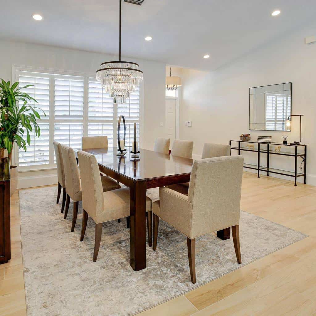 simple dining room wood table and chairs wall mirror large floor rug chandelier