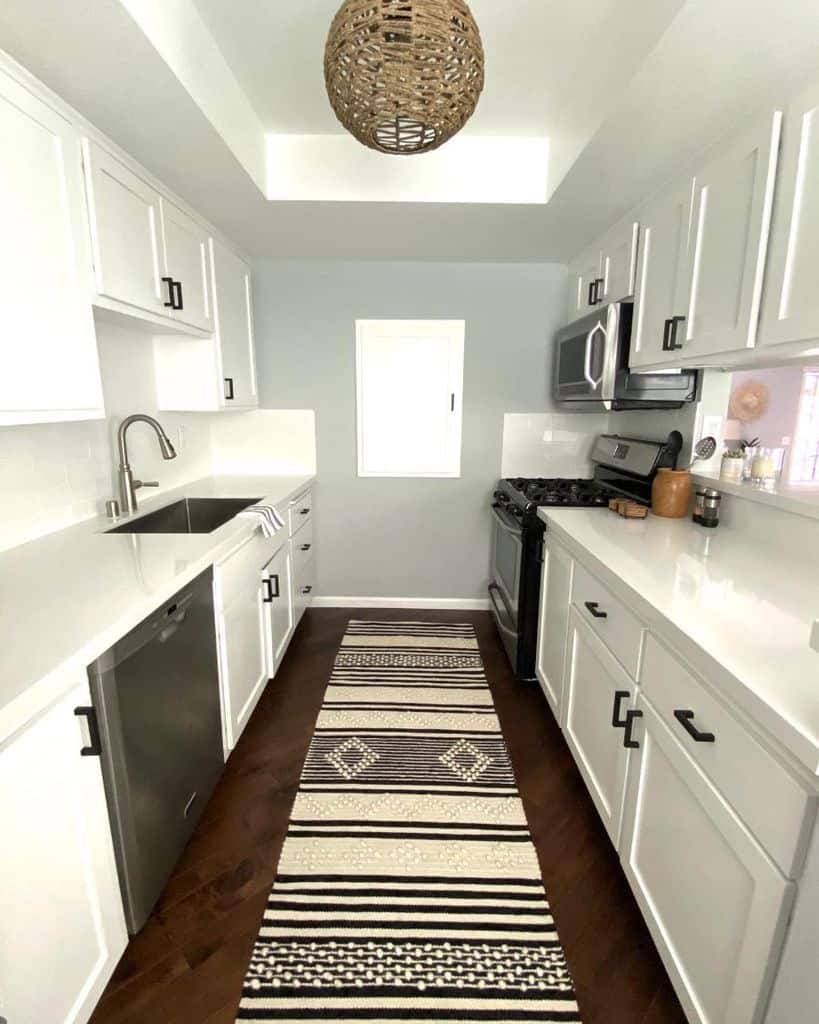 large white galley kitchen black accents pattern floor rug