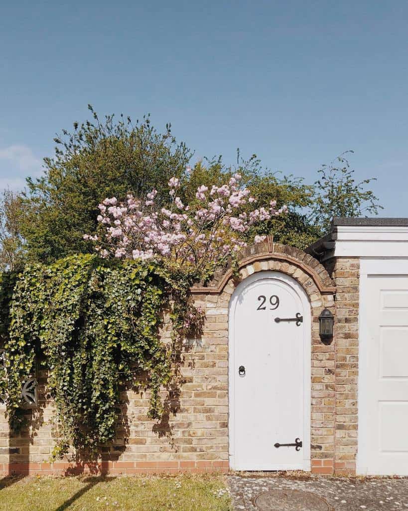 white garden gate in brick wall
