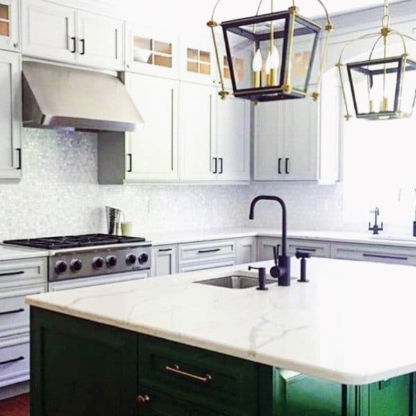 Kitchen with white cabinets, green island, marble countertop, and mosaic tile backsplash.