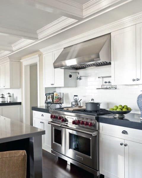 The kitchen features white cabinetry with a dark countertop, stainless steel appliances, and a clean, modern look.
