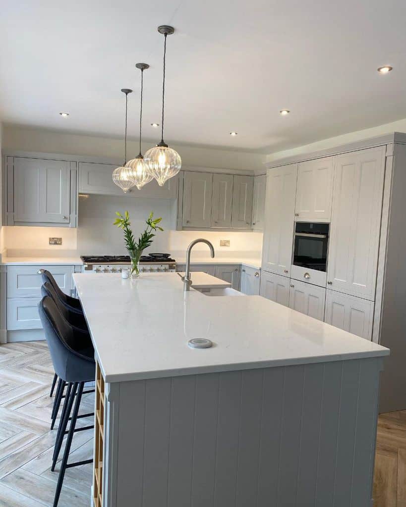 large white kitchen three seats white countertop pendant track lighting