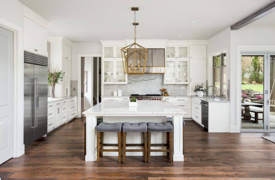 large open kitchen with white cabinets and hardwood floors