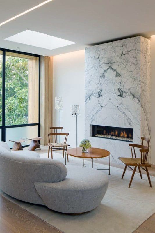 White marble fireplace exudes sophistication, complementing the modern living room with natural elegance and warmth.