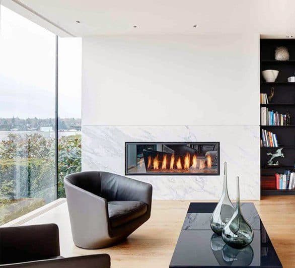 A sleek white marble fireplace blends luxury with modern design, creating a cozy yet elegant focal point for the living space.