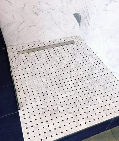 Marble walls with a tiled shower floor and sleek linear drain