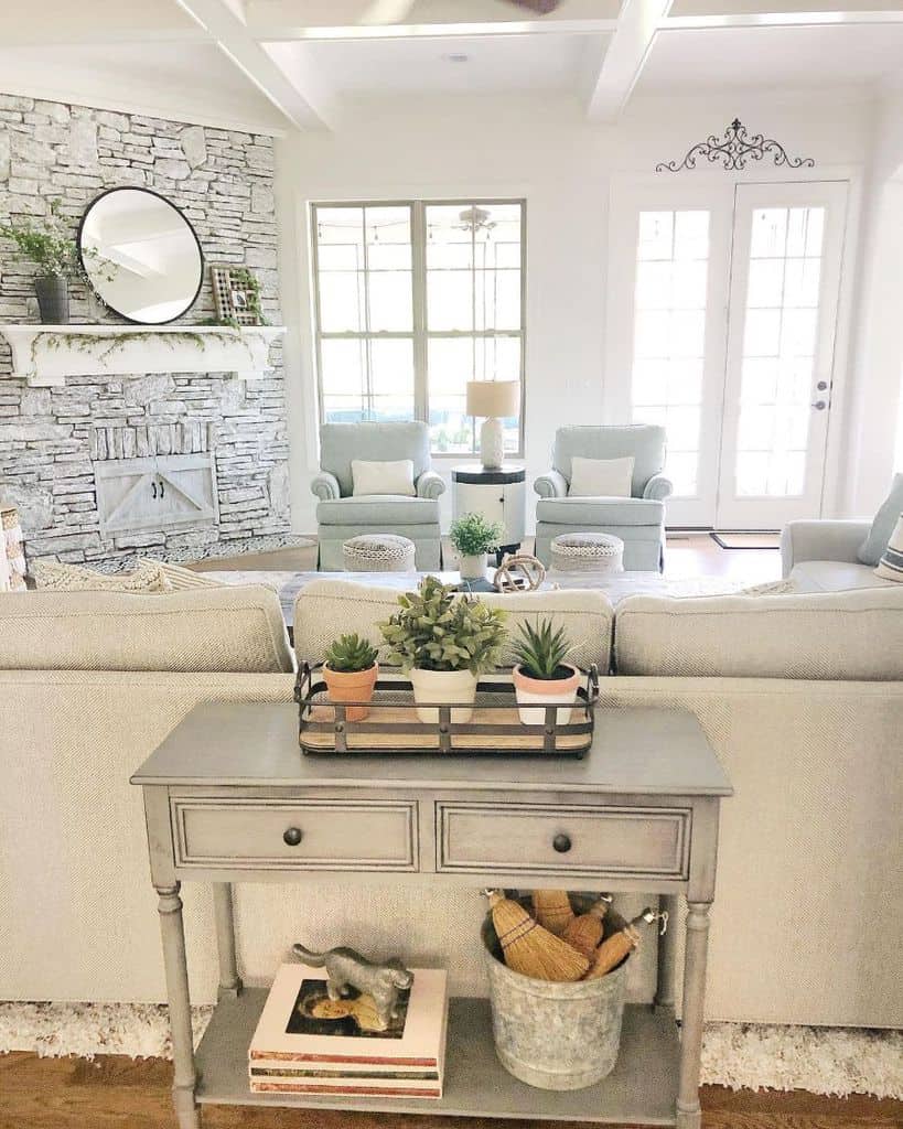 modern farmhouse living room brick fireplace mantle mirror gray sofa blue lounge chairs gray wood cabinet