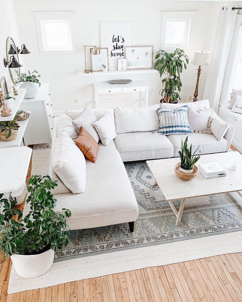 white farmhouse living room l-shape sofa plants pattern floor rug