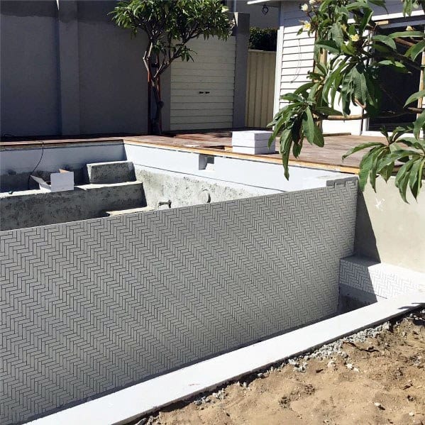 Chic backyard pool featuring white patterned tiles, perfect for a modern aesthetic.