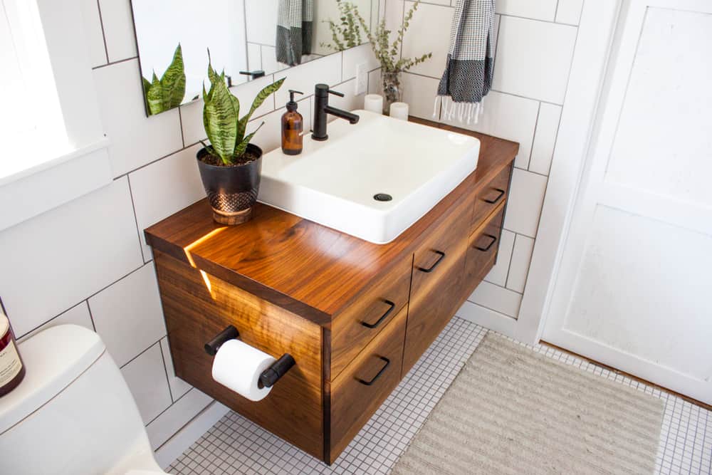 white powder room with wood vanity 