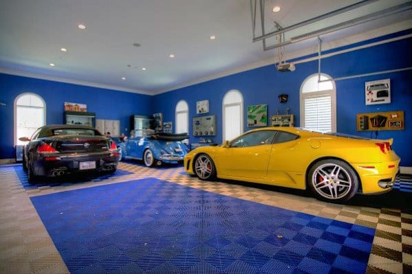 Vibrant garage with blue walls, white ceiling, and luxury cars on patterned flooring.