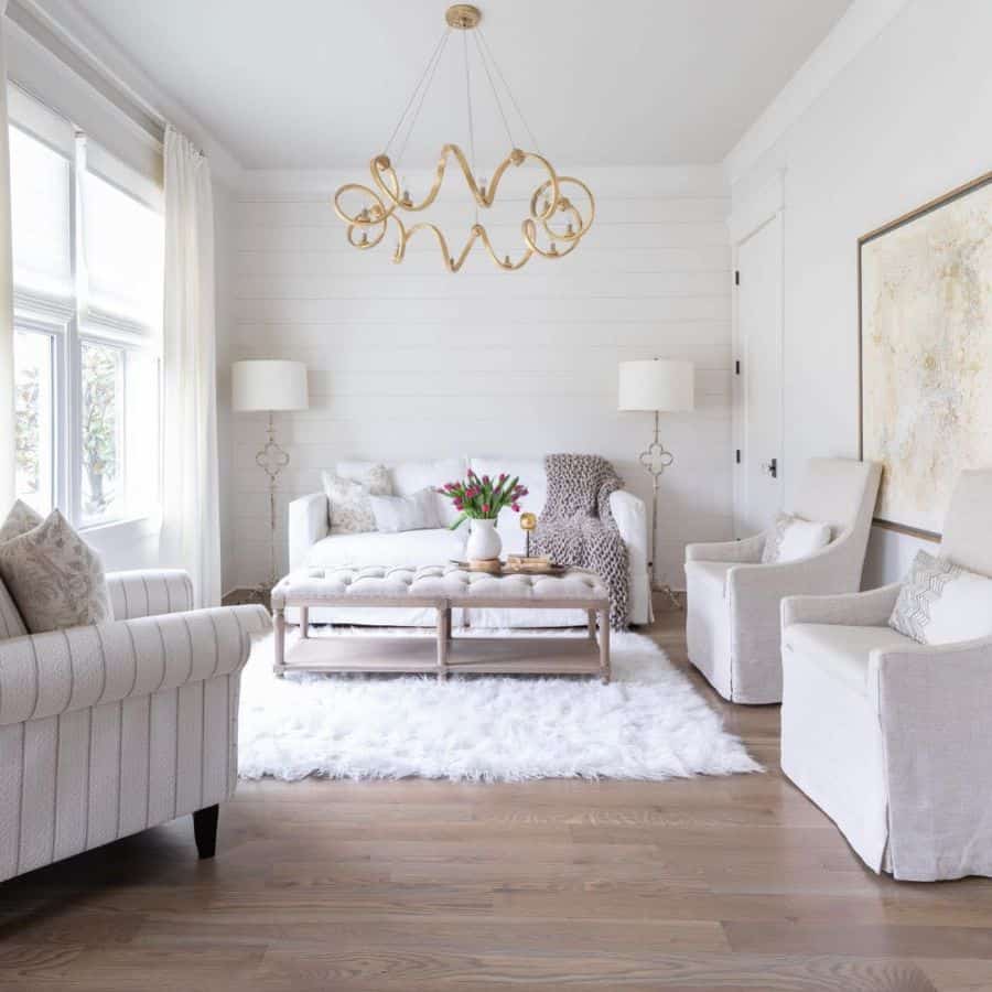 white living room with sofa and armchairs vinyl wood flooring
