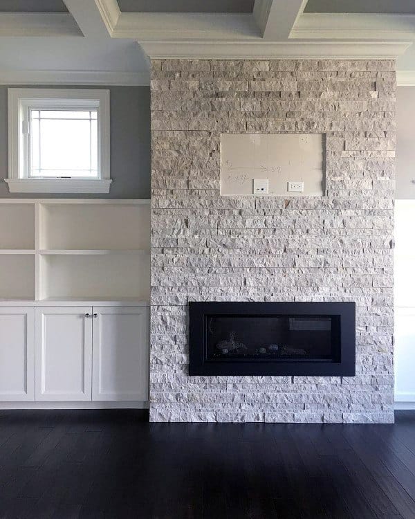 White stone fireplace with a black frame, adding contrast and character to the room.