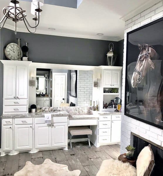 Rustic bathroom with white cabinets, large mirror, and horse painting