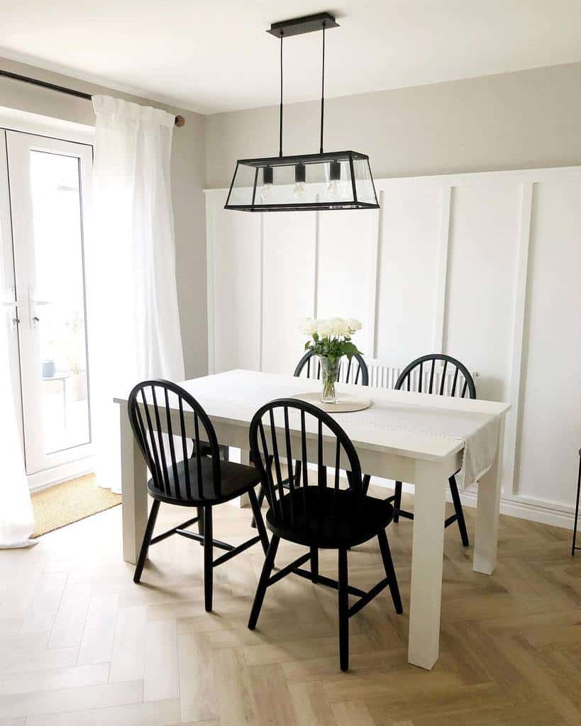 white wall paneling dining room track ceiling lighting black chairs white table
