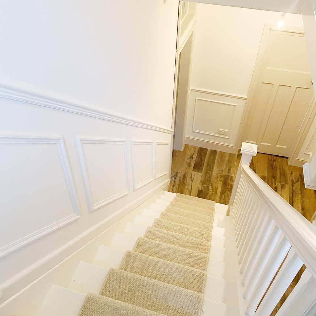 white wall paneling carpet stairs