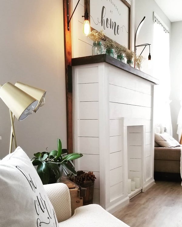 white shiplap wood faux fireplace surround black mantle gold floor lamp