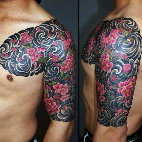 Half-sleeve Japanese tattoo showcasing vibrant cherry blossoms intertwined with swirling wind patterns and rich black shading